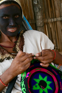 Why do the Wayuu paint their faces?